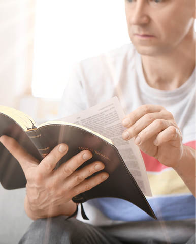 Man reading Bible at home