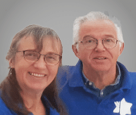 A man and woman are standing together, both wearing blue shirts. AI generated content