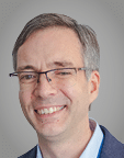 A man wearing a purple sweater. Description generated by AI