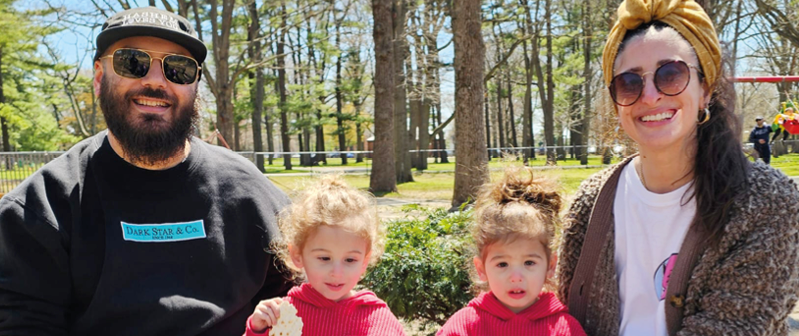 A man and two children sitting on a bench. Description generated by AI