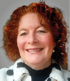 A woman with red hair and a white and black jacket. Description generated by AI