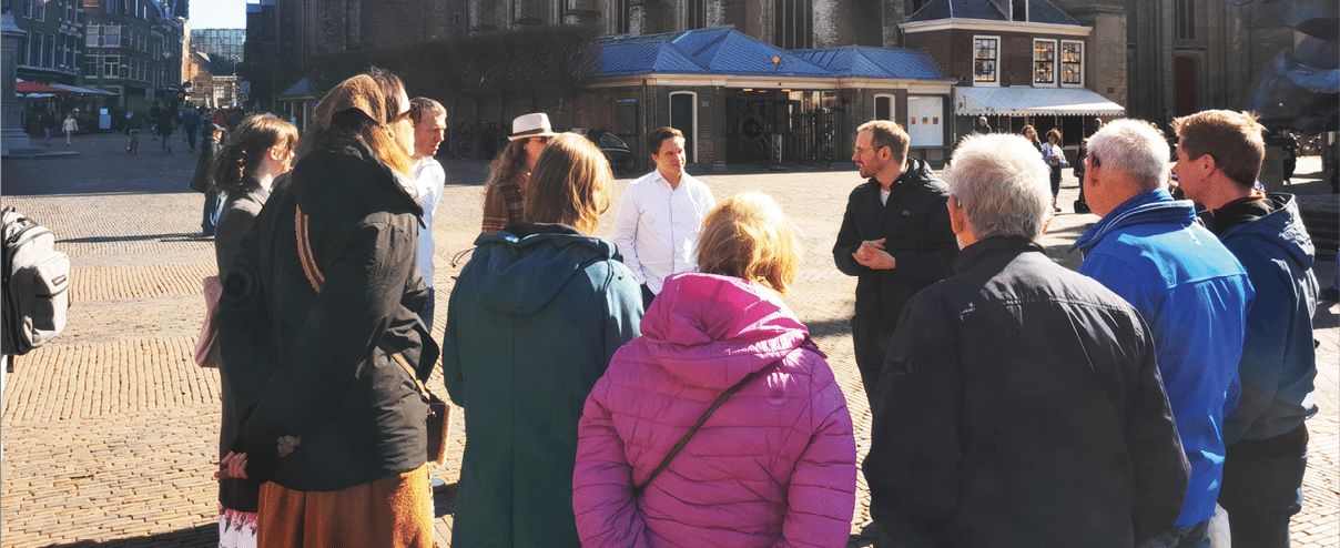 A group of people standing in front of a building. Description generated by AI