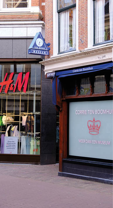 A storefront with a blue awning and a window with a crown on it. Description generated by AI