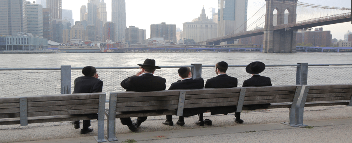BROOKLYN, NEW YORK - MAY 2, 2019: Jewish orthodox teenagers enjoy outdoors near Brooklyn Bridge in New York