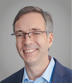 A man wearing a purple sweater. Description generated by AI