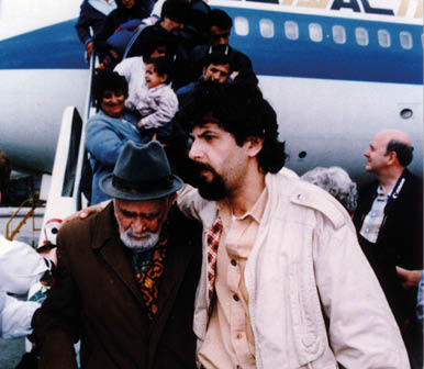 A group of people are getting off an airplane. Description generated by AI