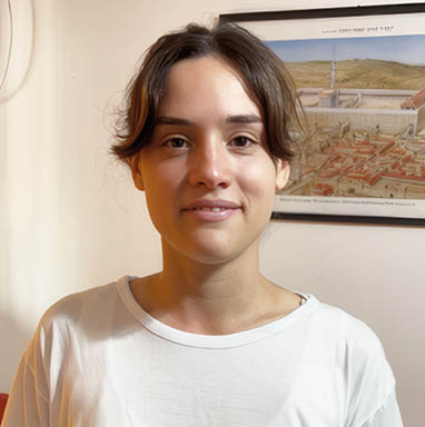 A young woman wearing a white shirt with a blue star on it. Description generated by AI