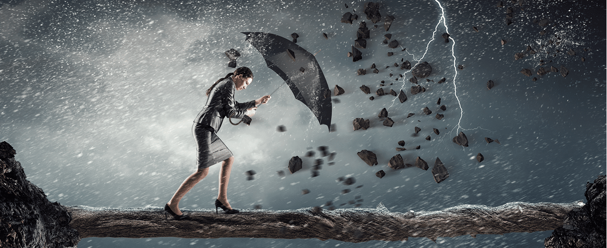 Young determined businesswoman with umbrella walking against strong wind