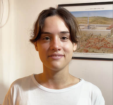 A young woman wearing a white shirt with a blue star on it. Description generated by AI