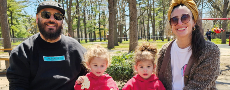 A man and two children sitting on a bench. Description generated by AI