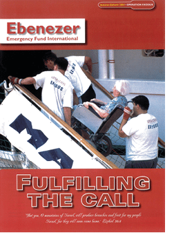 Three adults wearing white shirts with “Operation Exodus" printed on them are helping a person with white hair in a wheelchair board a ship using a ramp. Description generated by AI
