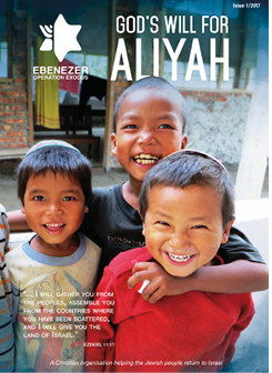 Three children wearing traditional head coverings stand closely together outdoors with one child in the center hugging the other two, accompanied by text about a Christian organization helping Jewish people return to Israel. Description generated by AI