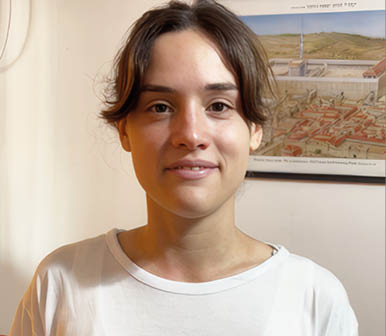 A young woman wearing a white shirt with a blue star on it. Description generated by AI