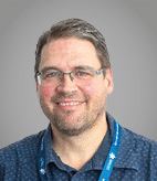 A man wearing a blue lanyard. Description generated by AI
