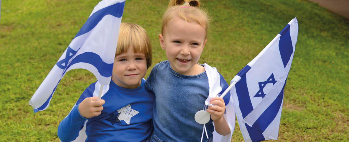 Two children holding Israeli flags. Description generated by AI