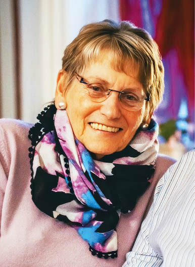 A woman wearing a scarf with a pattern of blue, black, and white. Description generated by AI