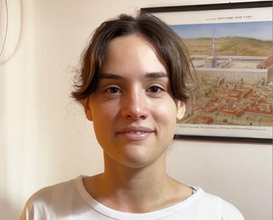 A young woman wearing a white shirt with a blue star on it. Description generated by AI