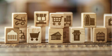 A stack of wooden blocks with various symbols on them, including a shopping cart