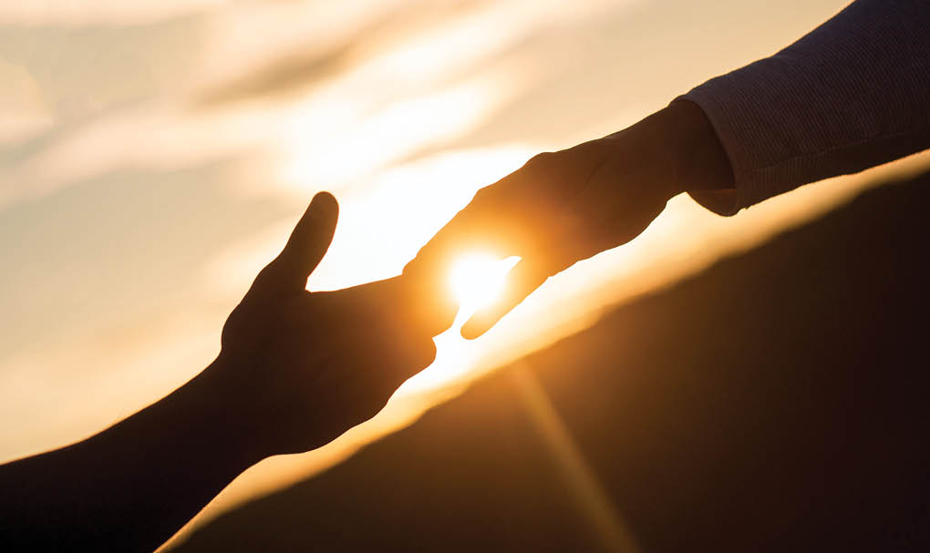 Giving a helping hand  Rescue, helping gesture or hands  Two hands silhouette on sky background, connection or help concept 