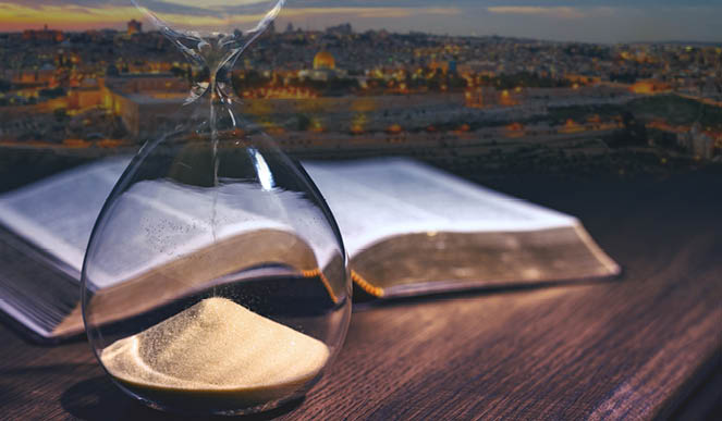 Hourglass and open bible symbolizing the end times according to the Holy Bible  Time is running out 