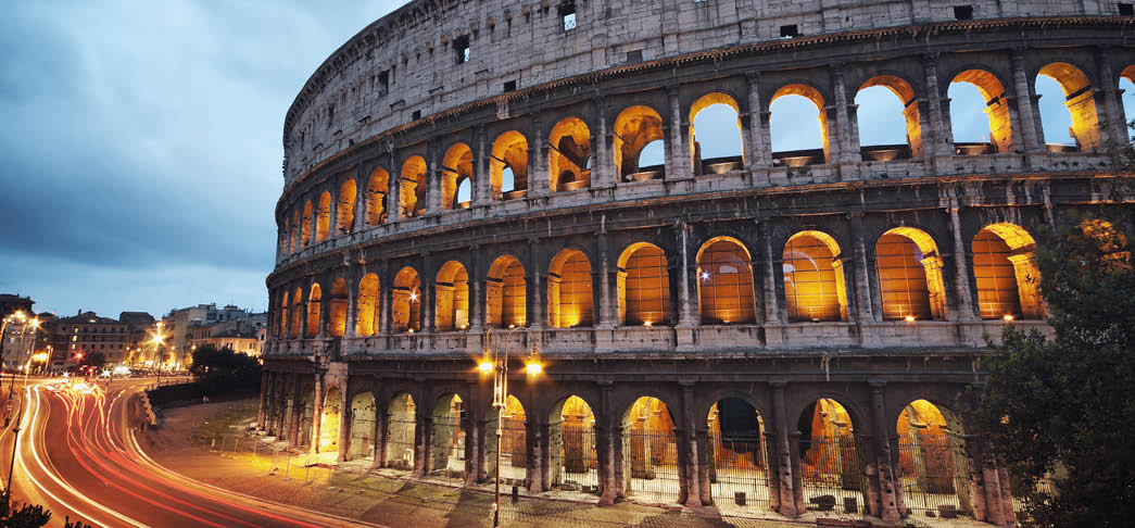 Coliseum at night with colorful blurred traffic lights 