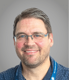 A man wearing a purple sweater. Description generated by AI