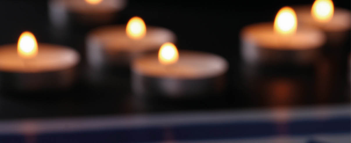 Burning candle and flag of Israel on black table. Holocaust memory day
