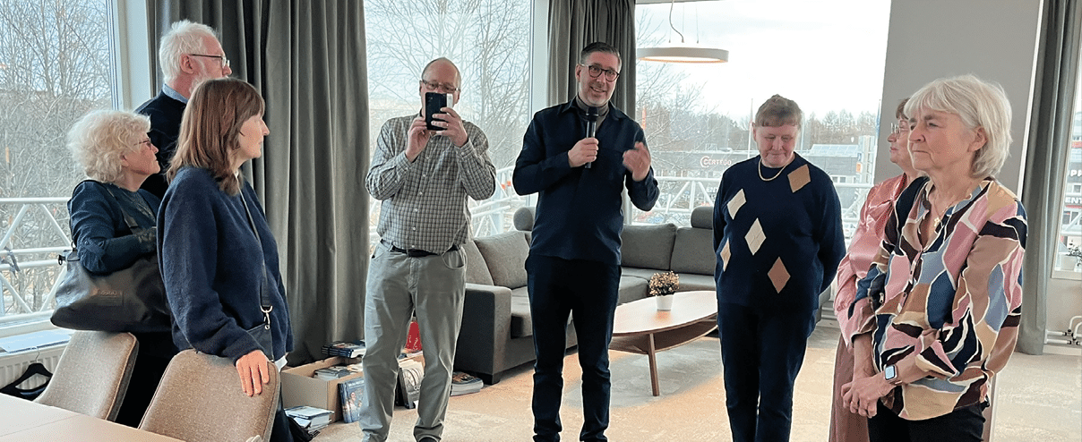 A group of people standing in a room. Description generated by AI